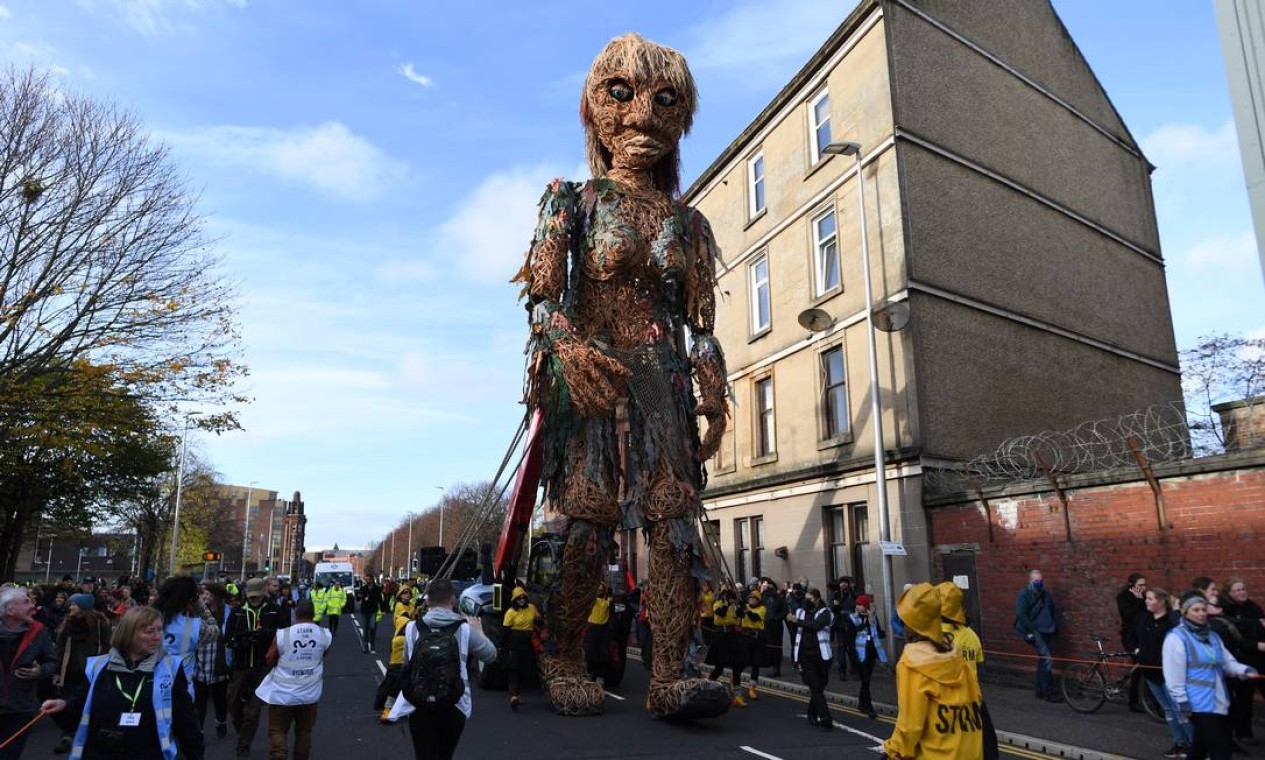 Storm, uma marionete da 'deusa do mar' de 10 metros de altura que carrega uma mensagem dos oceanos em crise, se move pelas ruas de Glasgow, durante a COP26, Conferência sobre Mudança Climática da ONU Foto: PAUL ELLIS / AFP
