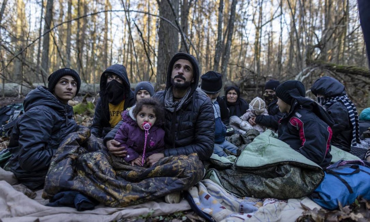 Família curda de Dohuk, no Iraque, espera em uma floresta perto da fronteira entre a Polônia e a Bielorrússia pela patrulha da guarda de fronteira, perto de Narewka, Polônia. A família de três gerações, com 16 membros, incluindo crianças, passou cerca de 20 dias na floresta e foi empurrada de volta para a Bielorrússia oito vezes. Eles afirmam que foram espancados e amedrontados com cães por soldados bielorrussos Foto: WOJTEK RADWANSKI / AFP