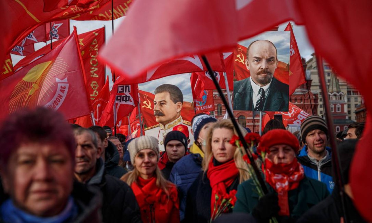 Ativistas e apoiadores do Partido Comunista Russo carregam retratos do fundador soviético Vladimir Lenin e do ditador soviético Josef Stalin durante uma cerimônia na Praça Vermelha, no centro de Moscou, marcando o 104º aniversário da Revolução Bolchevique Foto: DIMITAR DILKOFF / AFP