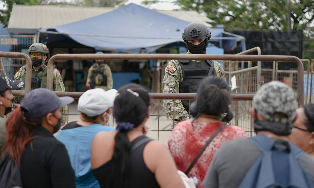 Militares observam parentes dos detentos do lado de fora do Complexo Prisional do Litoral, em Guayaquil, no Equador Foto: VICENTE GAIBOR DEL PINO / REUTERS