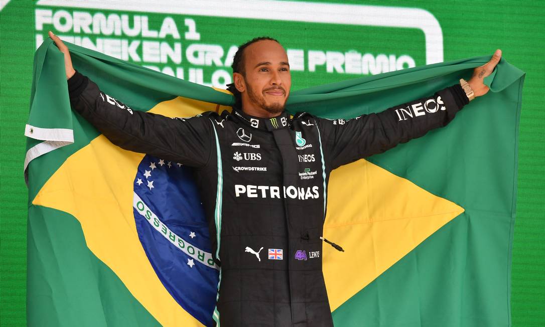 Lewis Hamilton comemora vitória com bandeira do Brasil em Interlagos Foto: NELSON ALMEIDA / AFP