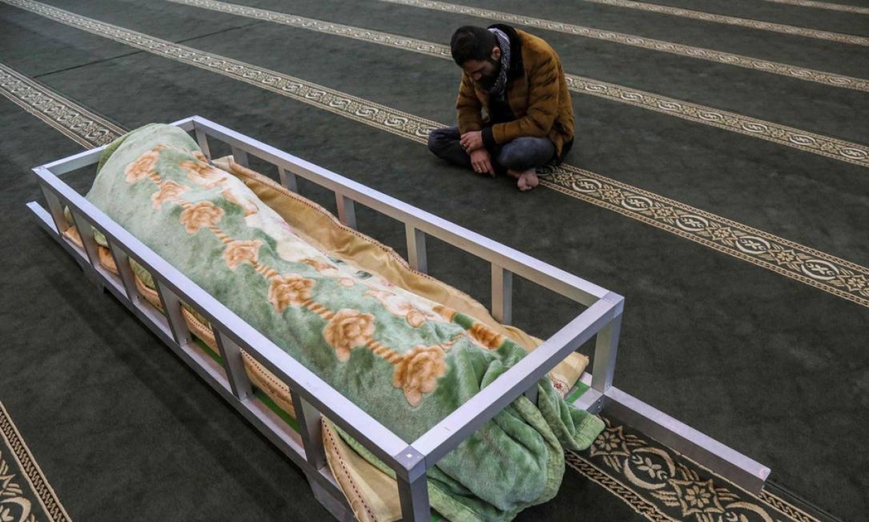 Homem vela o corpo repatriado do imigrante curdo iraquiano Gailan Diler, que morreu enquanto tentava cruzar ilegalmente para a Europa, durante seu funeral em Arbil, capital da região curda autônoma do norte do Iraque Foto: SAFIN HAMED / AFP