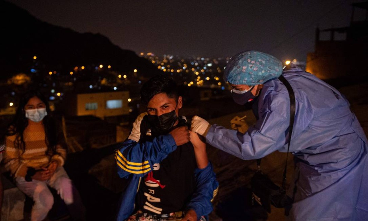 Profissional de saúde aplica vacina contra COVID-19, no distrito de Santa Anita, na periferia leste de Lima, Peru Foto: ERNESTO BENAVIDES / AFP