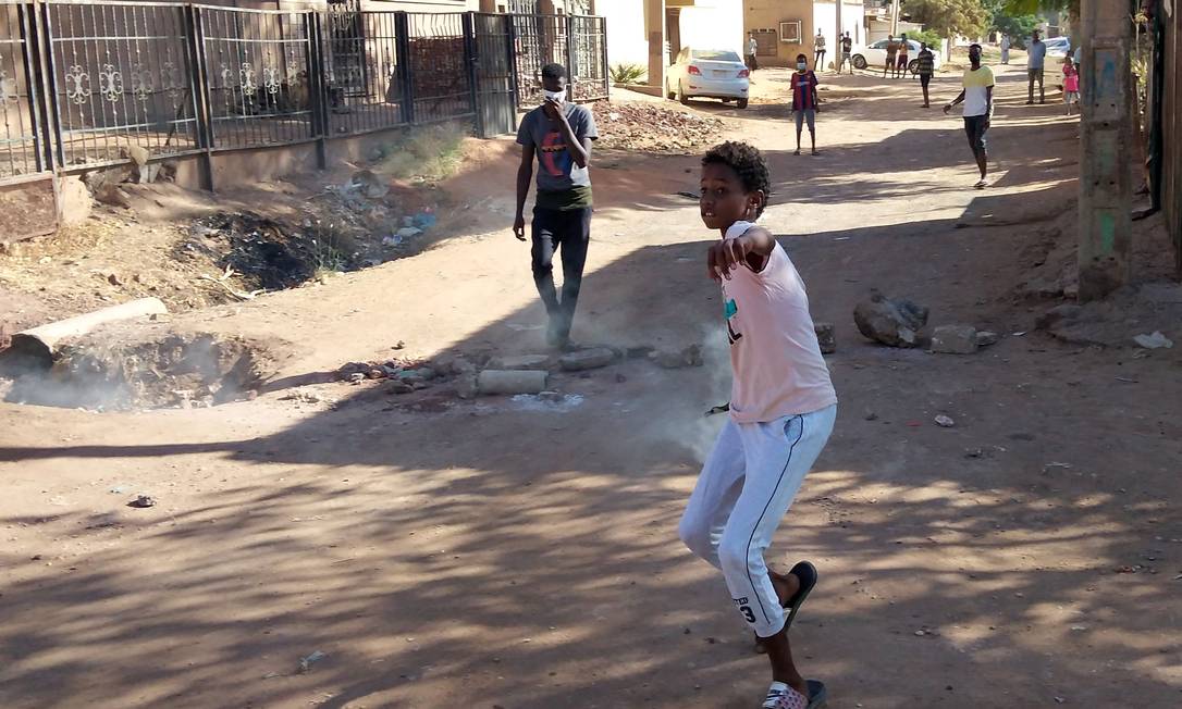 Jovem sudanês lança de volta bomba de gás lacrimogêneo jogada pelas forças de segurança Foto: AFP