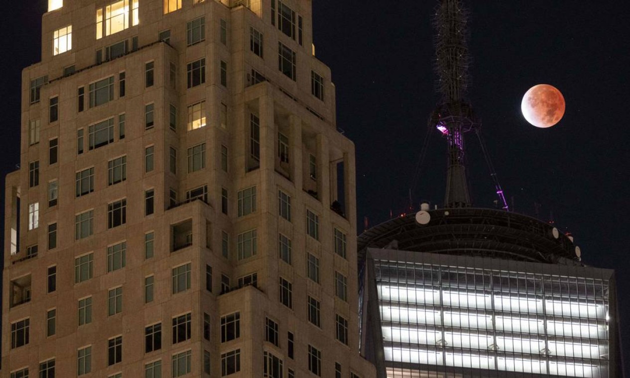 A lua é vista durante o eclipse próximo ao One World Trade Center em Nova York Foto: YUKI IWAMURA / AFP