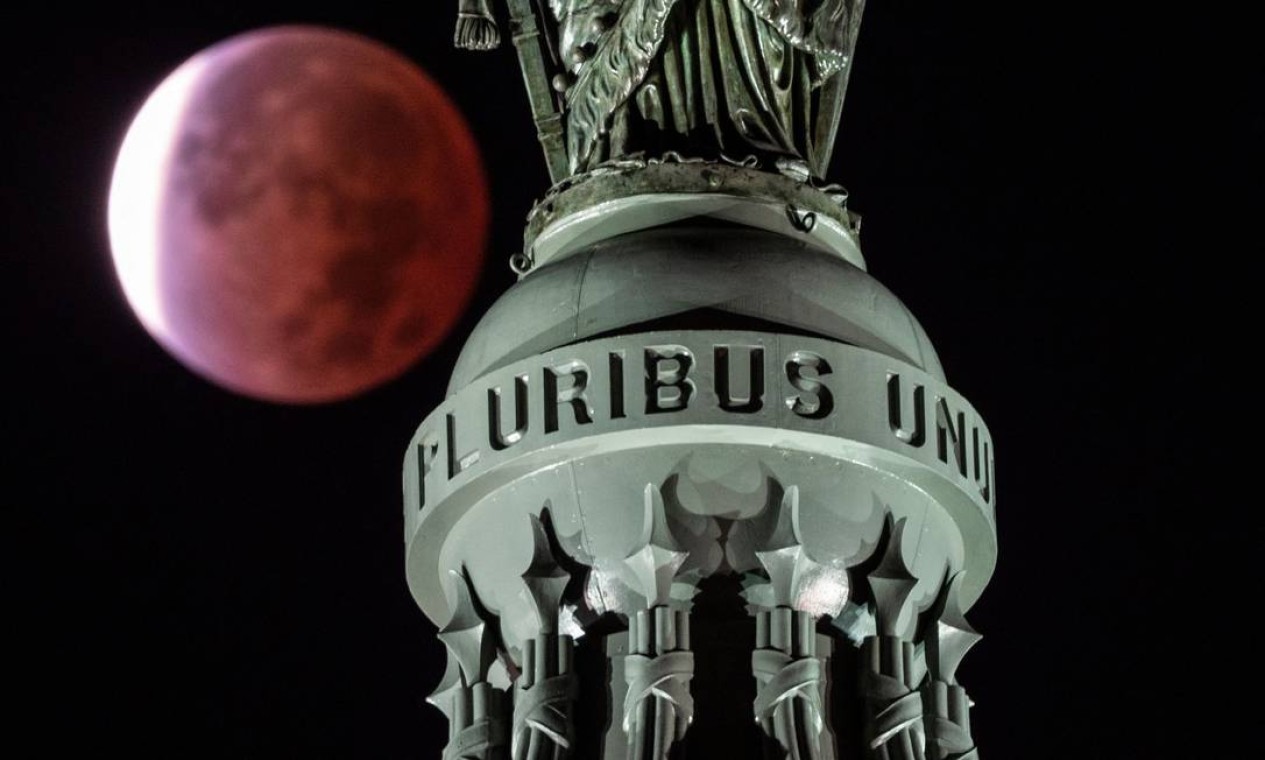 Eclipse lunar parcial é vista por trás da escrita E Pluribus Unum ("De muitos, um", em latim) na Estátua da Liberdade no topo da cúpula do Capitólio em Washington, DC, EUA Foto: ANDREW CABALLERO-REYNOLDS / AFP