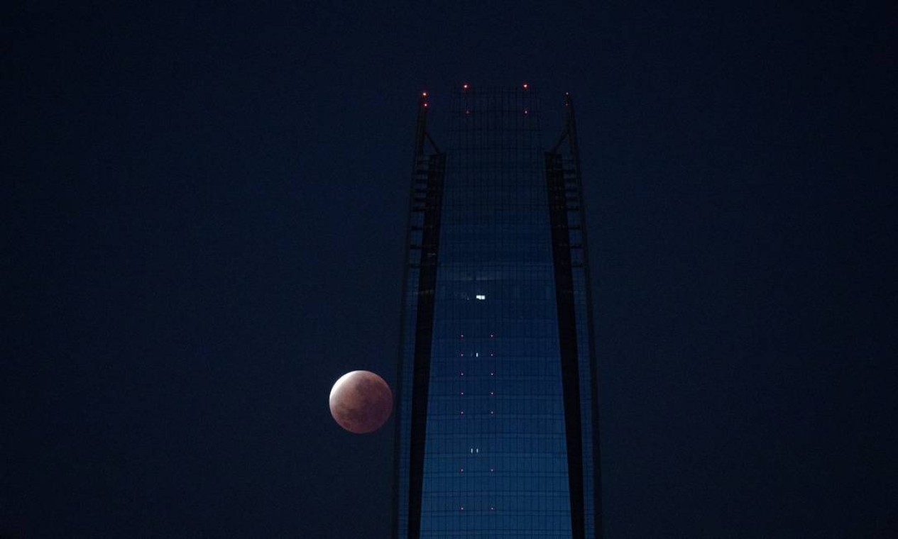 Eclipse lunar parcial é visto próximo ao prédio da Gran Torre em Santiago, Chile Foto: Pablo Sanhueza / REUTERS