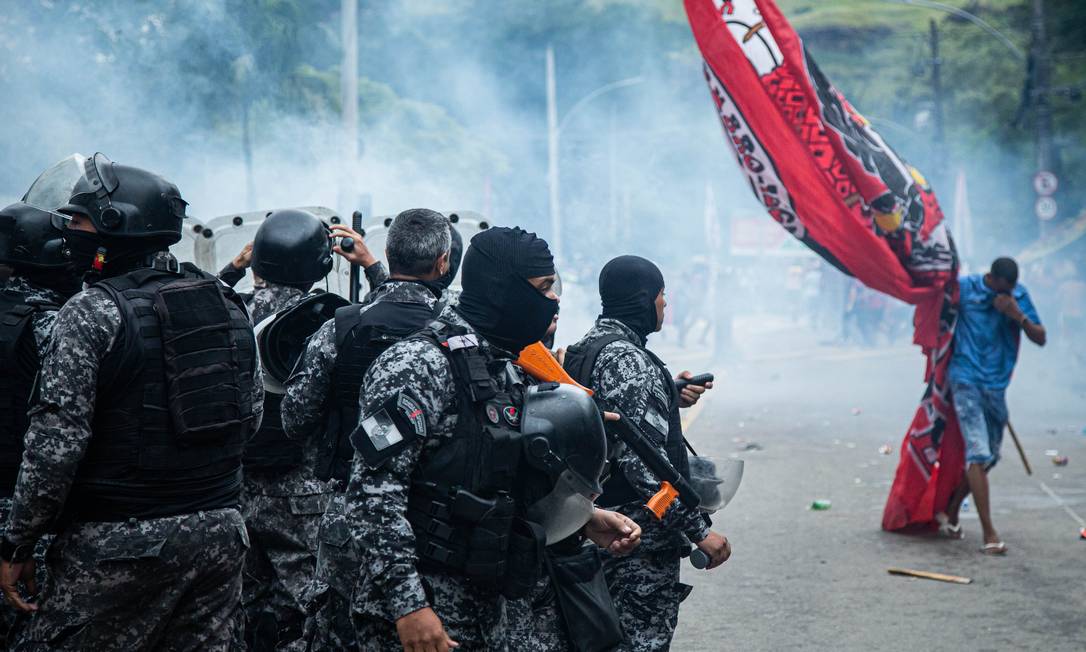 Torcedor carregando bandeirão do Flamengo reage a gás disparado pela polícia Foto: Hermes de Paula / Agência O Globo