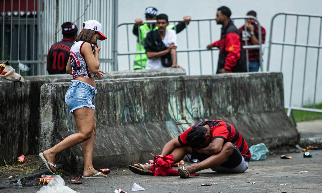 Torcedores tentam se proteger de gás atirado pela polícia Foto: Hermes de Paula / Agência O Globo