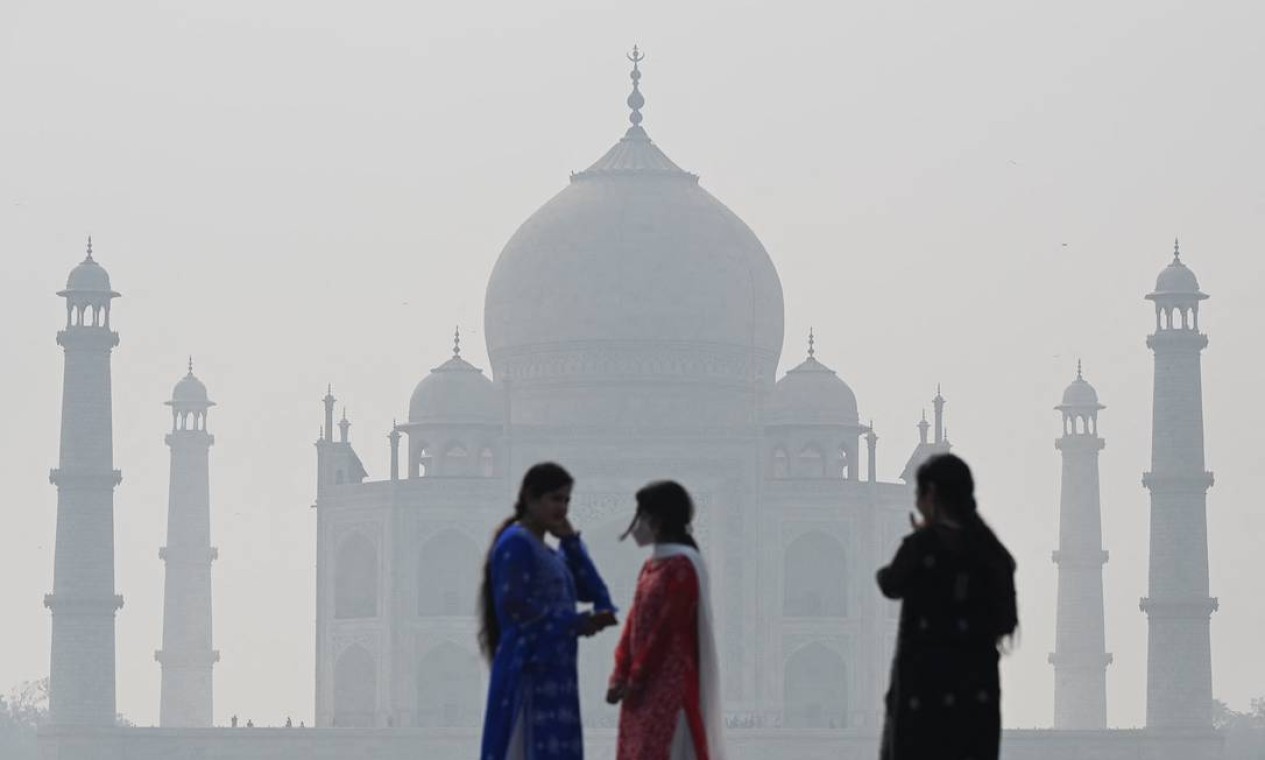 Pessoas visitam o complexo Mehtab Bagh, atrás do Taj Mahal, em meio a condições de
poluição atmosférica em Agra Foto: SAJJAD HUSSAIN / AFP