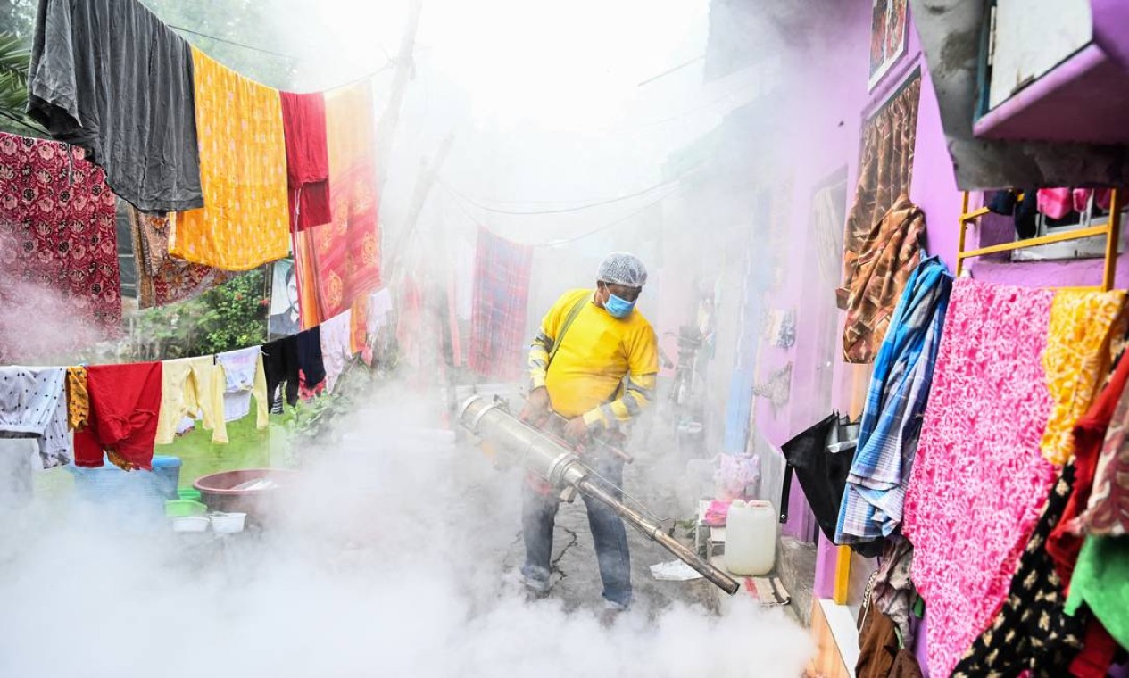 Funcionário municipal pulveriza favela como medida preventiva contra doenças transmitidas por mosquitos em Calcutá Foto: DIBYANGSHU SARKAR / AFP