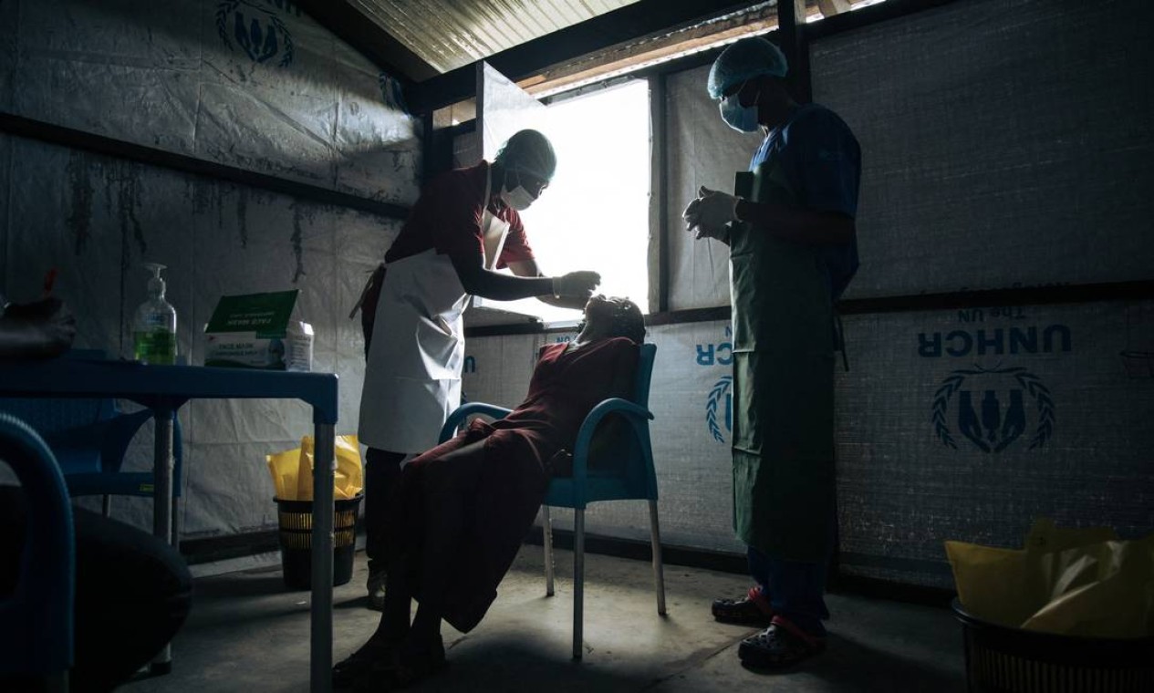 Equipe médica realiza testes de Covid-19 em refugiados centro-africanos no campo de Inke, no norte da República Democrática do Congo, que aguardam o voo de repatriação para Bangui Foto: ALEXIS HUGUET / AFP