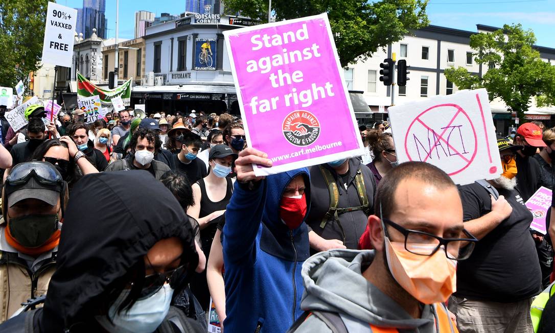 Manifestantes pró vacina se reúnem em Melbourne, na Austrália, com cartazes que pedem posicionamento contra a extrema-direita Foto: WILLIAM WEST / AFP