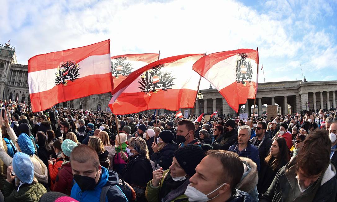 Manifestantes, em Viena, seguram bandeiras da Áustria durante protesto organizado pelo partido de extrema-direita FPO contra quarentena e vacinação obrigatória Foto: JOE KLAMAR / AFP
