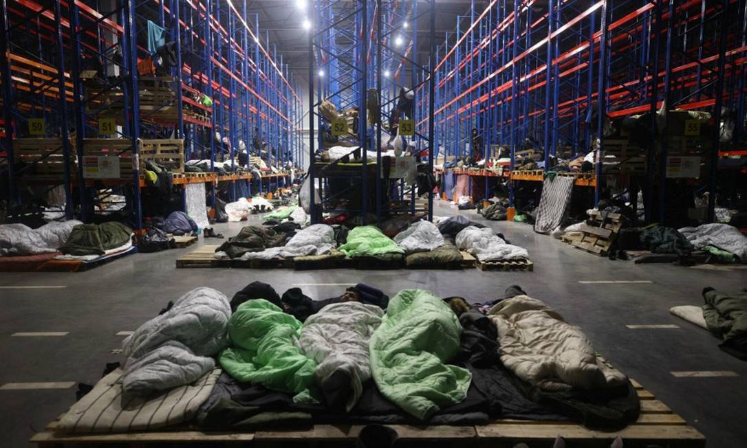 Imigrantes descansam em galpão transformado em abrigo na região de Grodno, fronteira entre Belarus e Polônia Foto: BELTA / via REUTERS