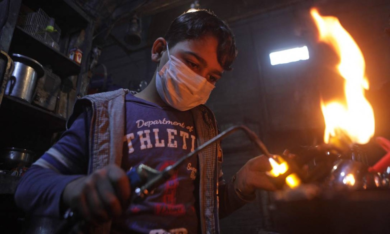 Adolescente sírio trabalha em uma fábrica de potes e panelas na cidade de al-Bab, no norte, controlada pela Turquia Foto: BAKR ALKASEM / AFP