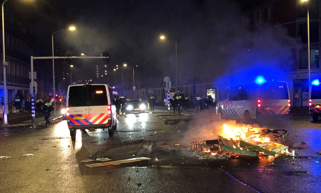 Manifestantes ateiam fogo em objetos durante ato contra a vacina em Haia, na Holanda Foto: DANNY KEMP / AFP