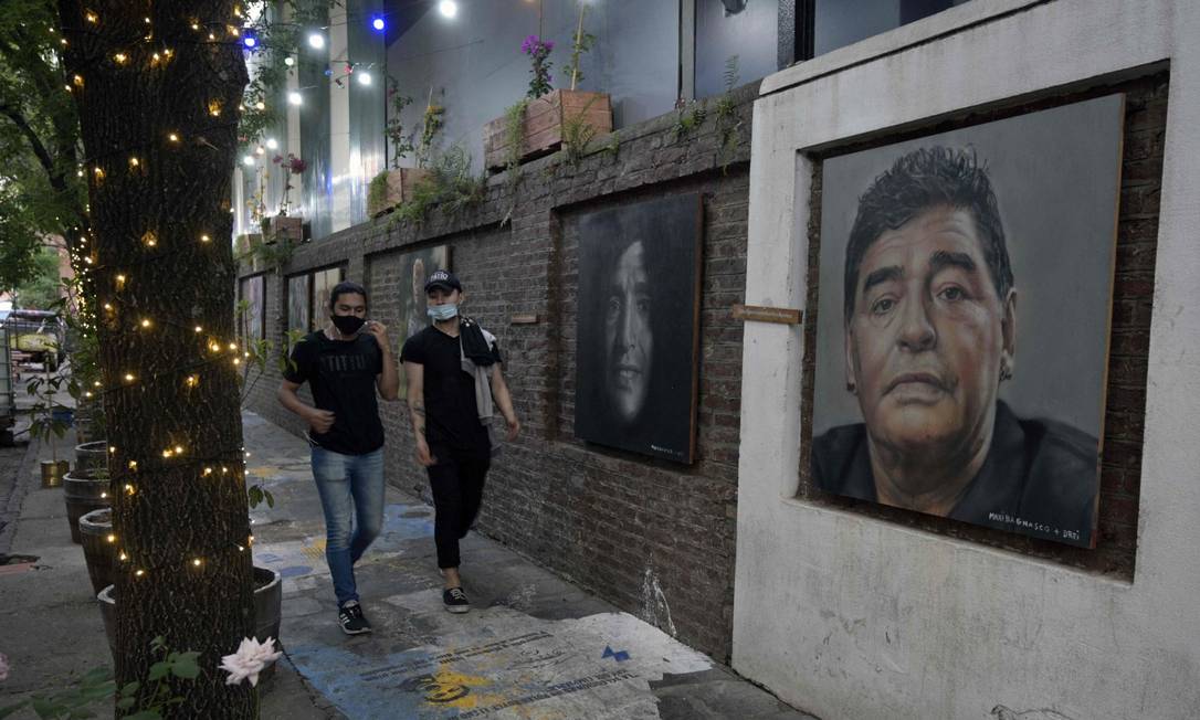 Dipinti degli artisti Maximiliano Bagnasco e Dreier Salamanca Vargas raffiguranti Diego Maradona fuori da un ristorante a Buenos Aires. Foto: JUAN MABROMATA / AFP
