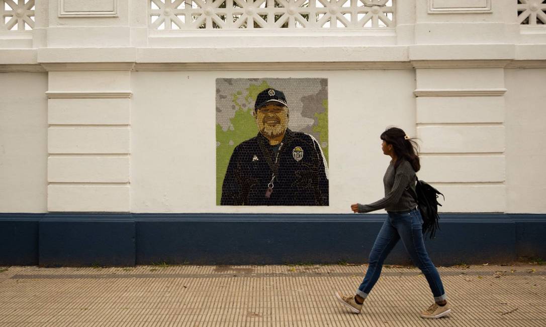 Una donna cammina davanti a un murale dipinto da Maradona allo stadio Juan Carmelo Zerillo di La Plata. Foto: TOMAS CUESTA / AFP