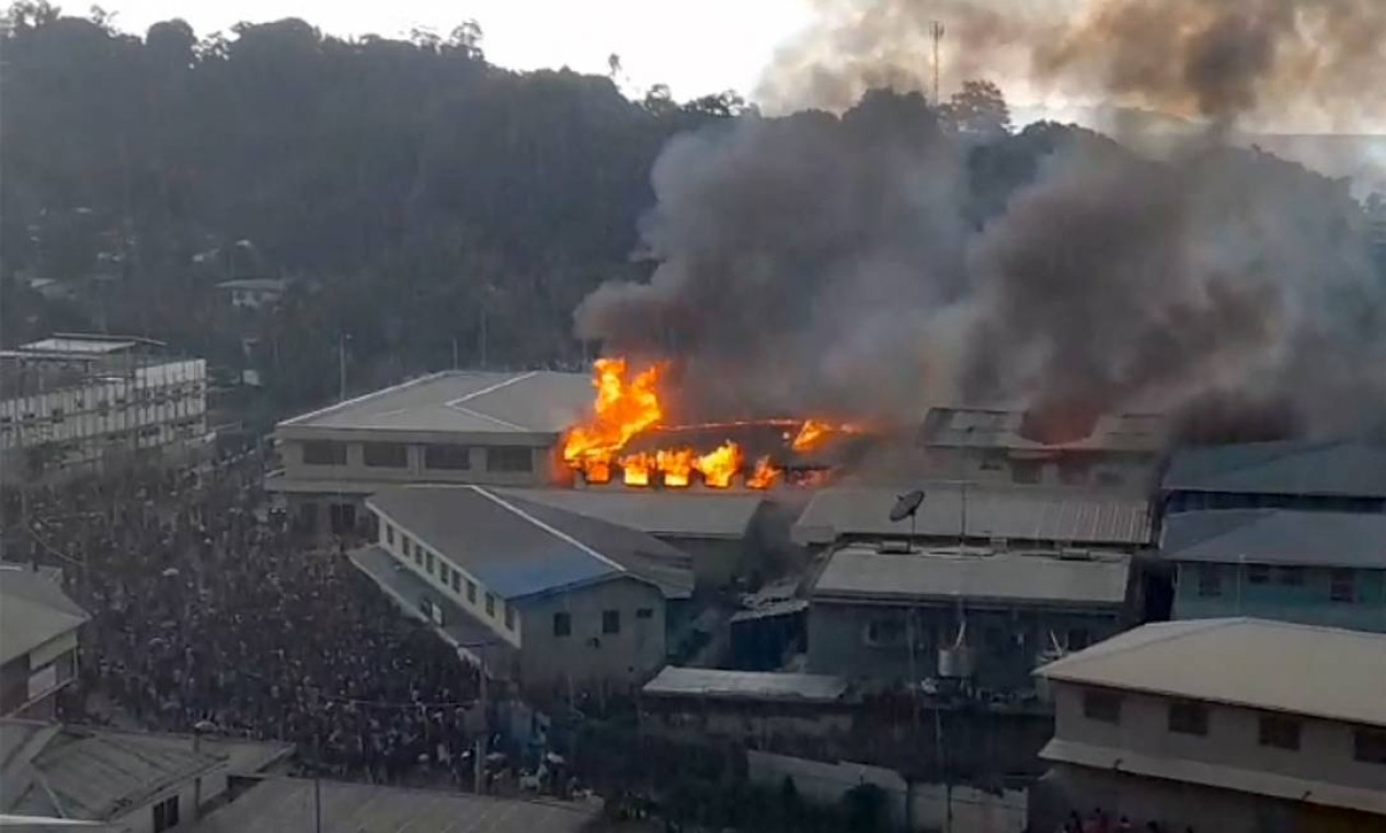 Partes do distrito de Chinatown ardem em chamas, em Honiara, nas Ilhas Salomão, durante protestos contra o governo Foto: JOB RONGO'AU FUOO / AFP