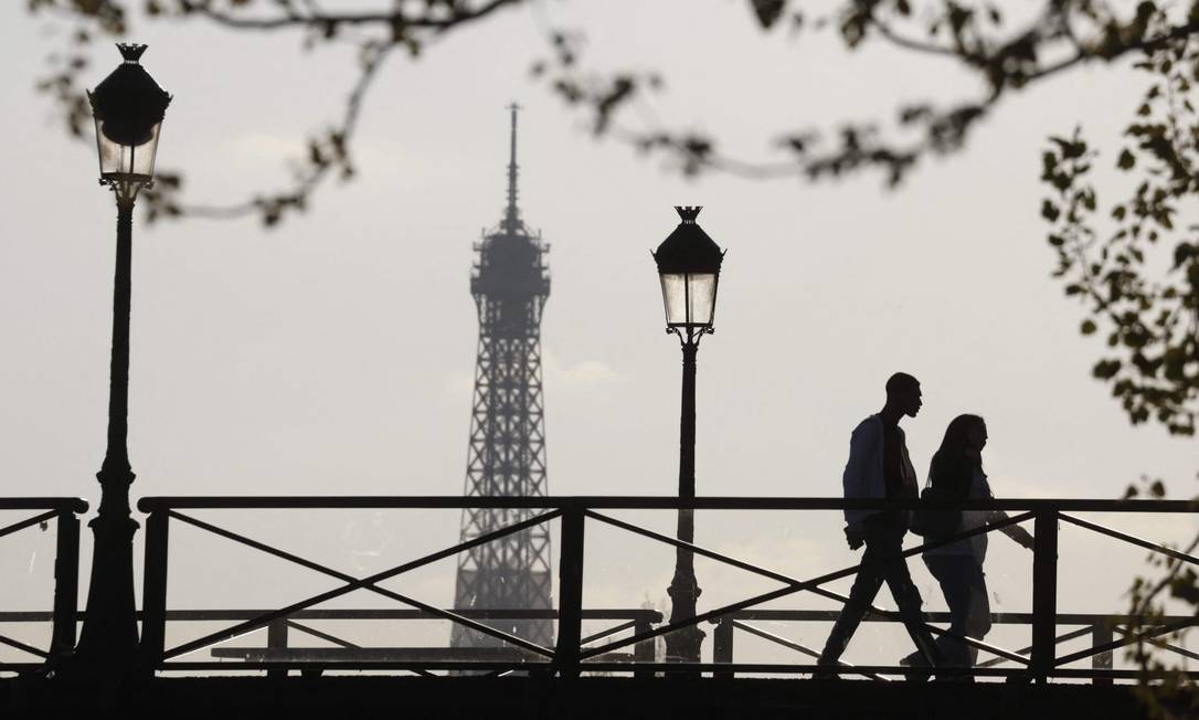Casal caminha pela Pont des Arts, em Paris Foto: LUDOVIC MARIN / AFP/19-4-21