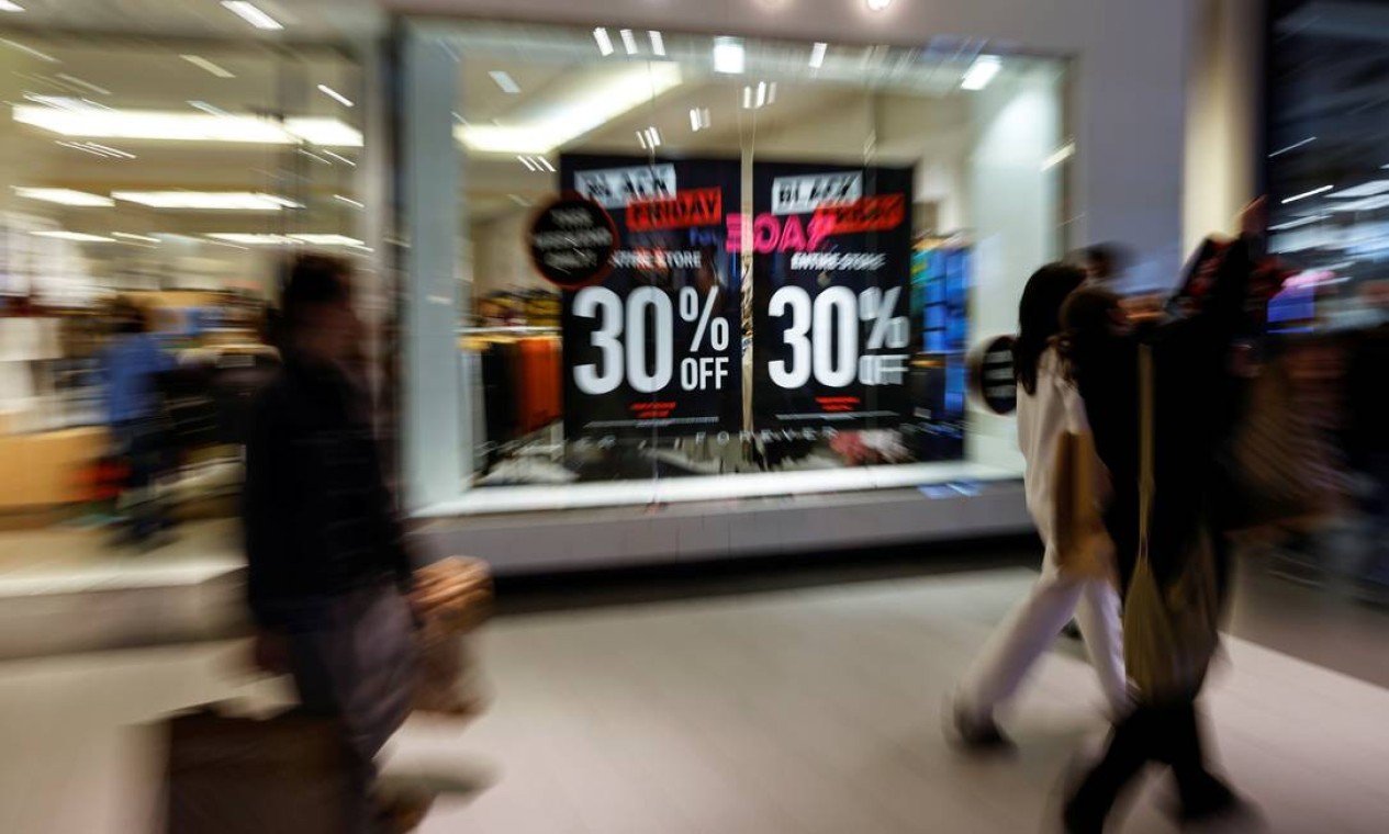 Os compradores passam por anúncios em uma loja de varejo durante as vendas da Black Friday no shopping Roosevelt Field em Garden City, Nova York, EUA Foto: SHANNON STAPLETON / REUTERS