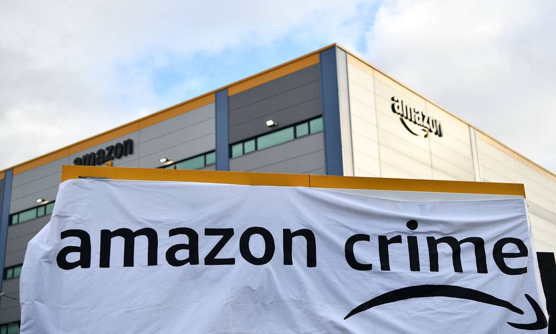 Ativistas do Extinction Rebellion (XR) afixaram cartaz com o logo &#039;Amazon Crime&#039; (um trocadilho com o plano de assinatura Amazon Prime) ao bloquear a saída de um centro de distribuição da Amazon durante um protesto em Tilbury, a leste de Londres Foto: BEN STANSALL / AFP