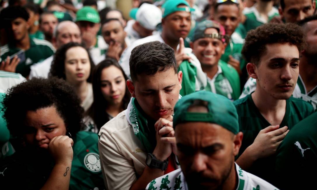 Fé no verdão. Torcedores se apegam à reza durante partida Foto: AMANDA PEROBELLI / REUTERS