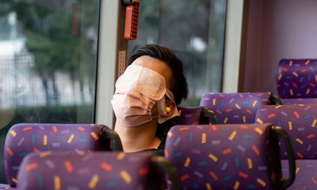 Passageiro dorme na viagem de ônibus 'para lugar nenhum' pelas ruas de Hong Kong, na China Foto: BERTHA WANG / AFP