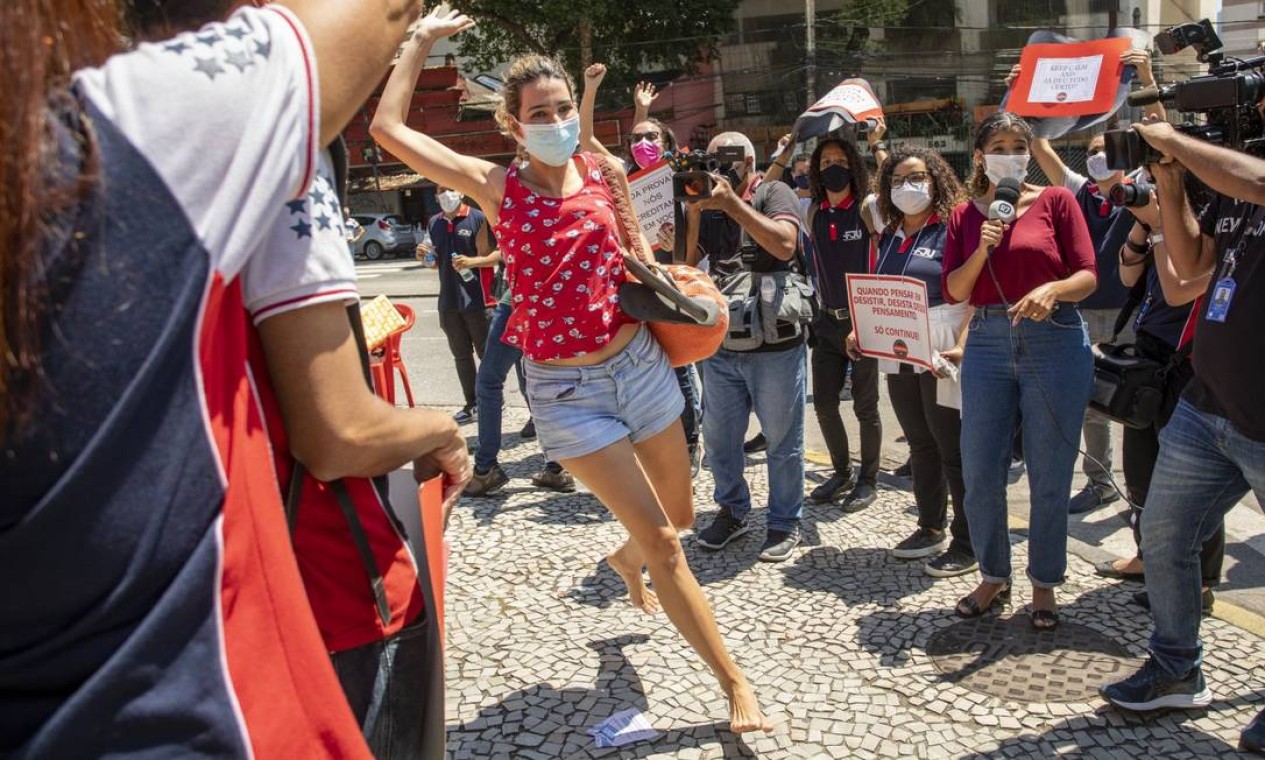 Candidata chega correndo e descalça próximo ao horário de fechar o portão na Uerj Foto: Ana Branco / Agência O Globo