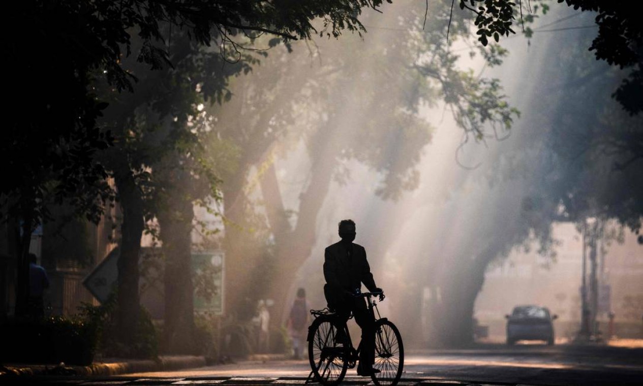 Homem anda de bicicleta ao longo de uma rua em meio à poluição atmosférica em Nova Delhi, Índia Foto: JEWEL SAMAD / AFP