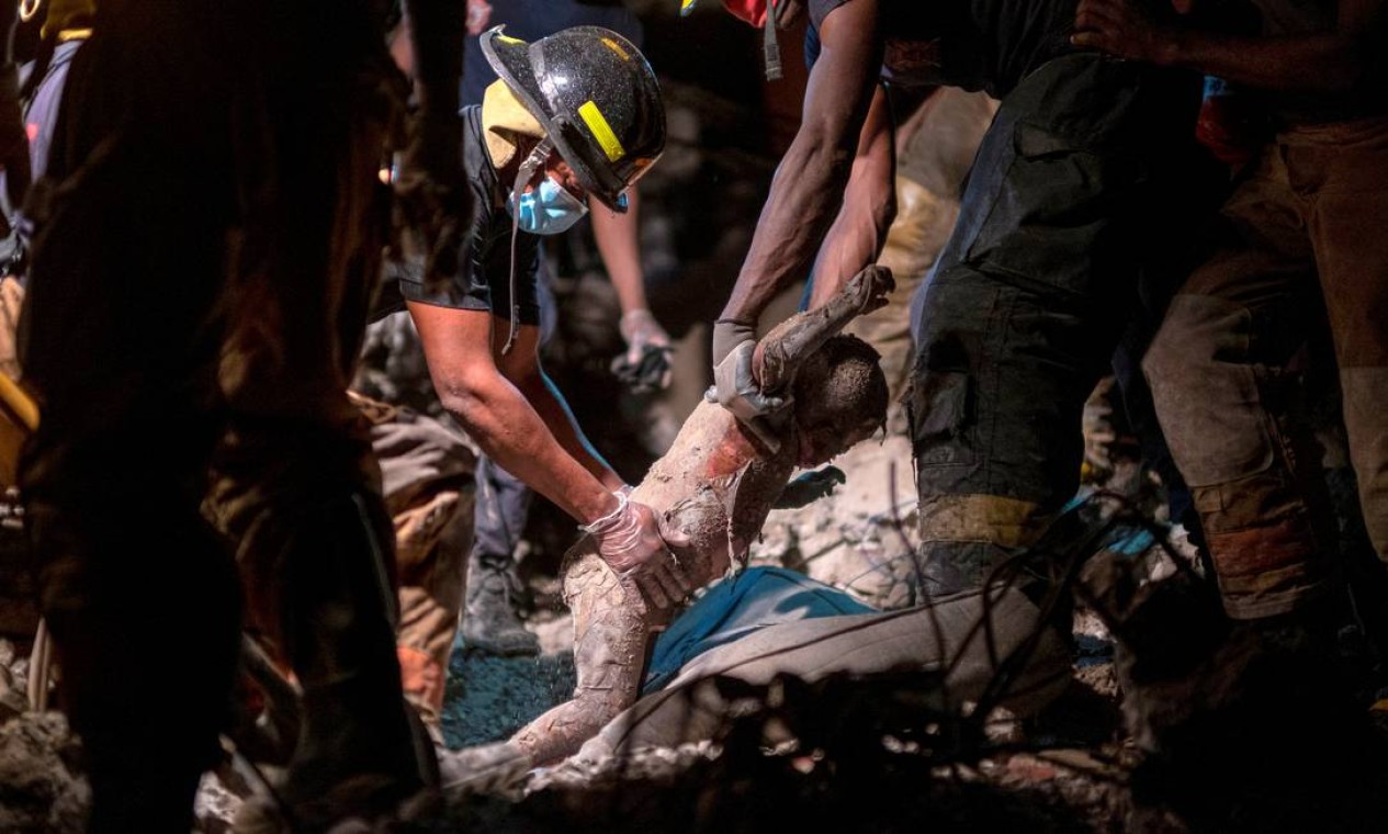 AGOSTO - Os bombeiros haitianos recuperam o corpo de um menino de três anos sob os escombros de um hotel destruído em um terremoto de magnitude 7,2, em Les Cayes, Haiti Foto: RICARDO ARDUENGO / REUTERS