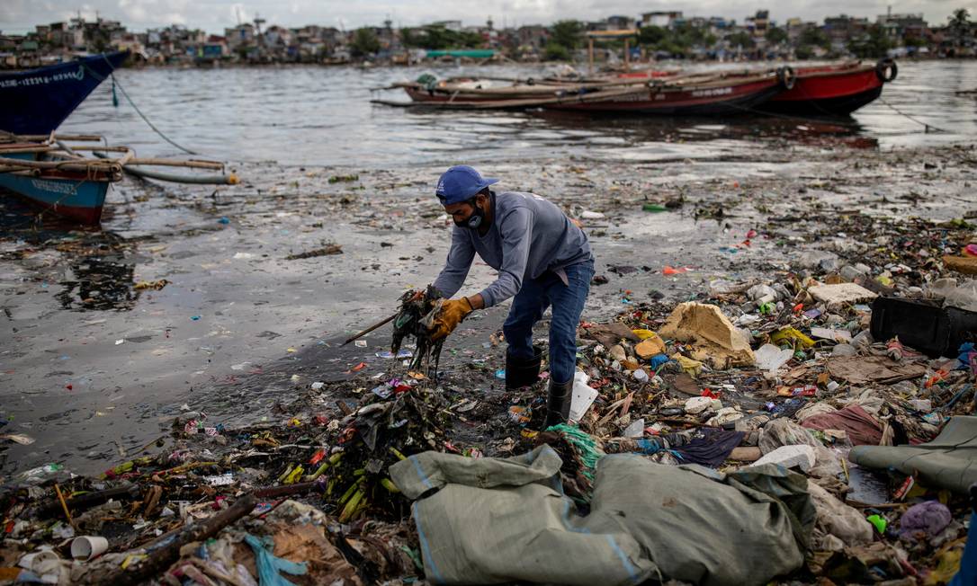 JUNHO - Argie Aguirre, um ativista dos River Warriors, coleta lixo do altamente poluído rio Pasig, em Baseco, Manila, Filipinas Foto: ELOISA LOPEZ / REUTERS