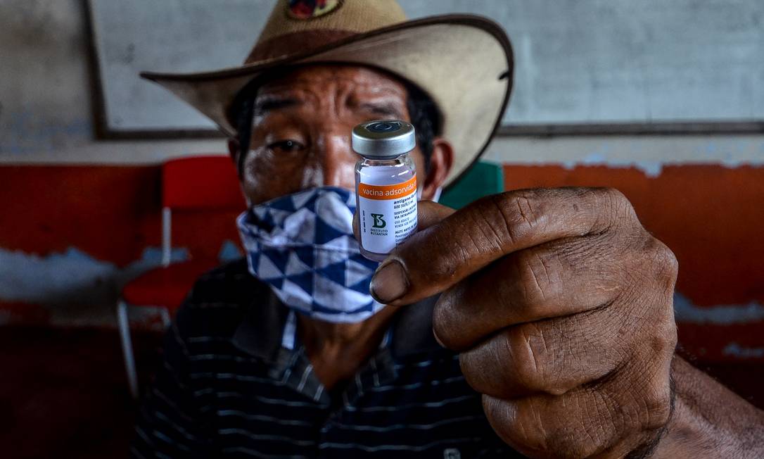 Morador do municipio de Moju, no Pará, mostra frasco de vacina Foto: JOAO PAULO GUIMARAES / AFP