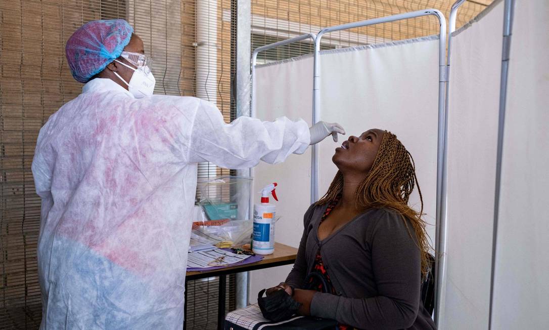 Mulher faz teste PCR para a Covid-19 no laboratório lancet, em Johanesburgo Foto: EMMANUEL CROSET / AFP