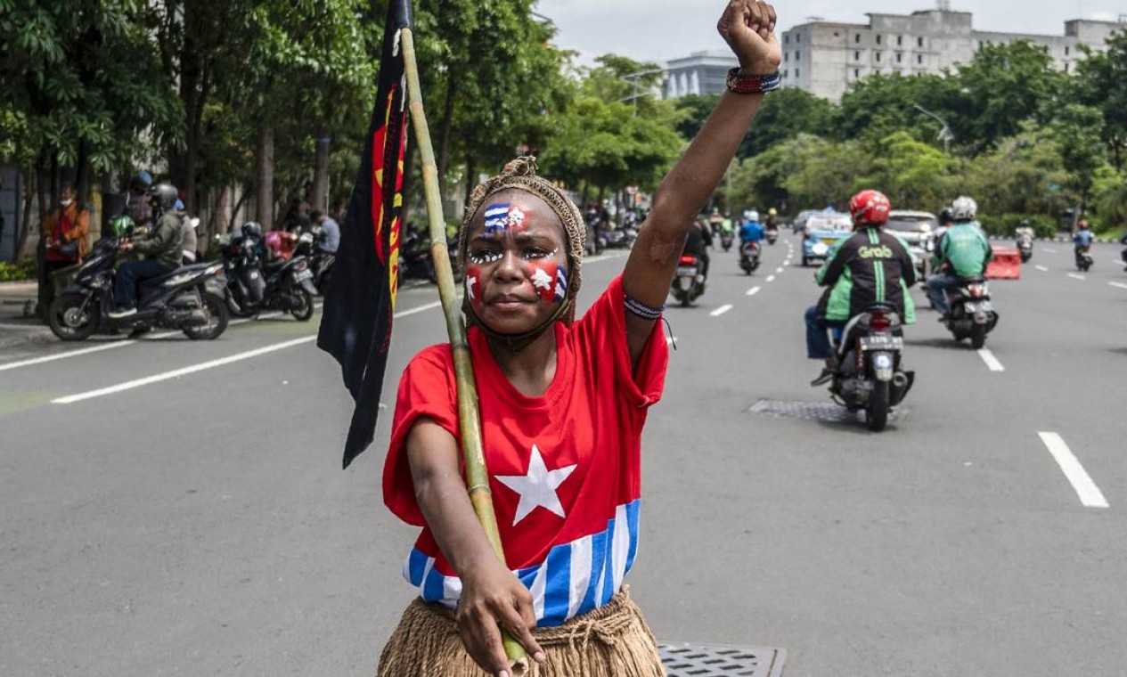 Estudante vestida com a bandeira da República de Papua Ocidental, gprotesta pela independência da província da Indonésia, na sede da polícia em Surabaya, no dia do aniversário do Movimento Papua Livre (OPM) Foto: JUNI KRISWANTO / AFP
