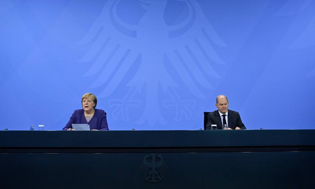 A chanceler Angela Merkel e seu sucessor, Olaf Scholz, participam de entrevista coletiva para anunciar novas restrições sanitárias Foto: JOHN MACDOUGALL / AFP