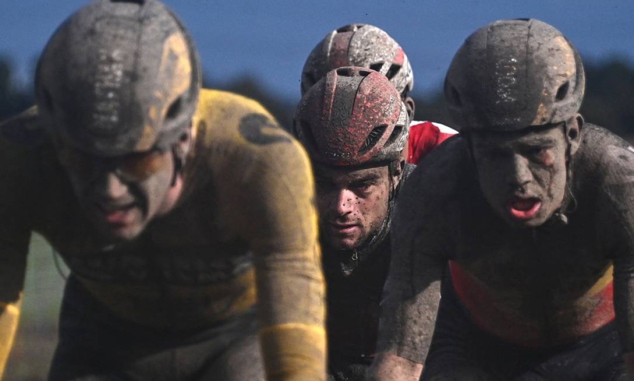 OUTUBRO - Pelotão aparecem totalmente cobertos por lama durante a 118ª edição de uma das provas mais tradicionais do ciclista de estrada, o Paris-Roubaix, entre Compiegne e Roubaix, norte da França Foto: ANNE-CHRISTINE POUJOULAT / AFP