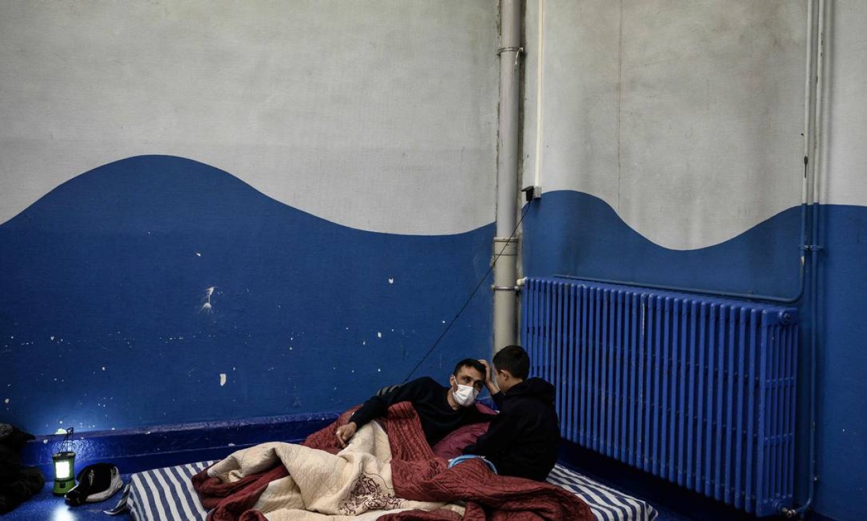 Membros de uma família albanesa sem-teto se preparam para dormir na escola primária Jean-Pierre Veyet, em Lyon, onde serão hospedados durante a noite, para se abrigar da onda de frio que atinge a França Foto: JEFF PACHOUD / AFP