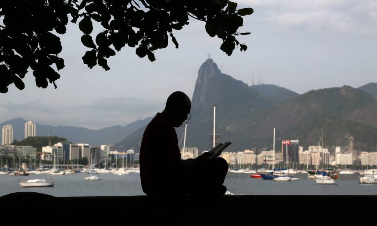Homem lê um livro sentado na tradicional mureta da Urca. Bairro completa seu primeiro centenário em 2022 Foto: Custodio Coimbra / Agência O Globo