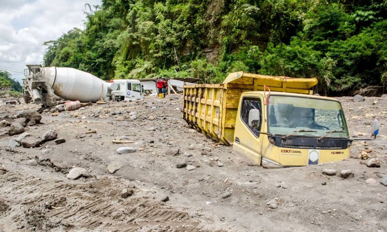 Caminhões de mineradores de areia ficam soterrados por cinzas vulcânicas depois que fortes chuvas deslocaram as cinzas das encostas do vulcão mais ativo da Indonésia, Merapi, em Magelang Foto: AGUNG SUPRIYANTO / AFP