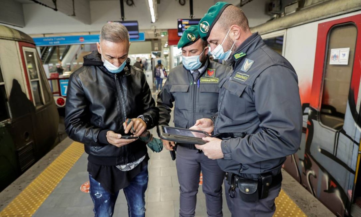 Oficiais da guardia verificam o passaporte vacinal da Covid-19 de um passageiro em uma estação de trem no dia em que o governo restringe o acesso de não vacinados, em Nápoles, Itália Foto: CIRO DE LUCA / REUTERS