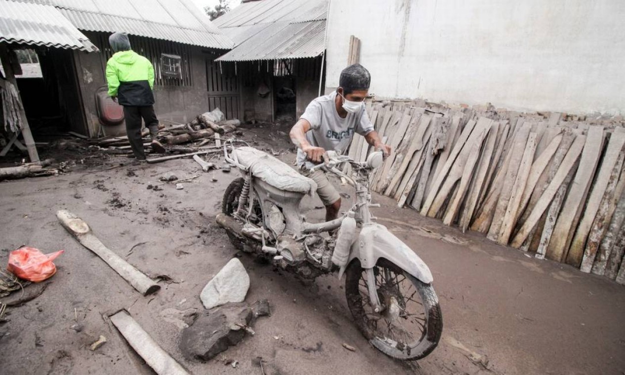 Morador empurra sua motocicleta coberta de cinzas após a erupção do vulcão Monte Semeru, em Sumber Wuluh, na província de Java Oriental Foto: ANTARA FOTO / via REUTERS