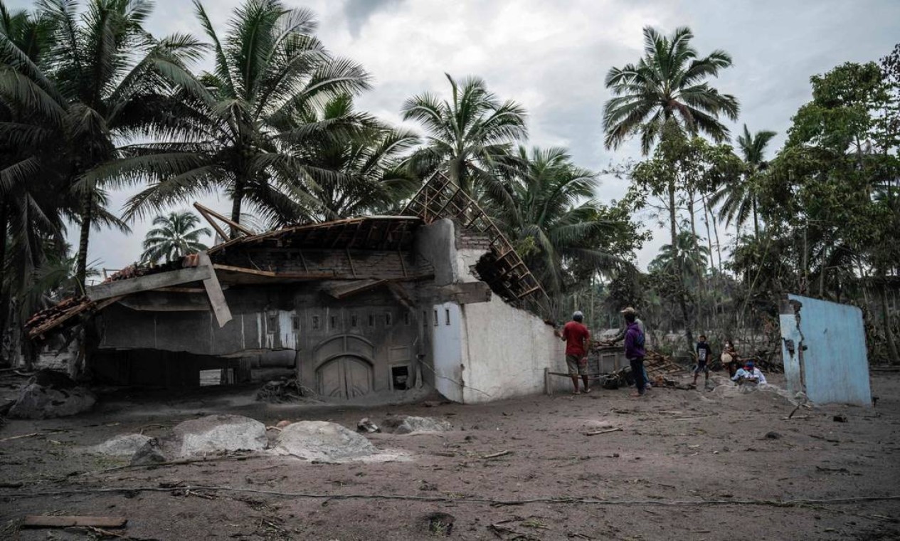 Aldeões resgatam o que podem de suas casas danificadas na aldeia Sumber Wuluh Foto: JUNI KRISWANTO / AFP