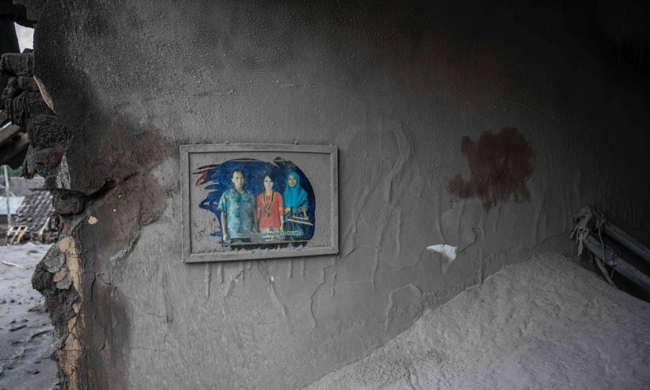Retrato de família é visto pendurado em uma casa danificada na vila de Sumber Wuluh Foto: JUNI KRISWANTO / AFP