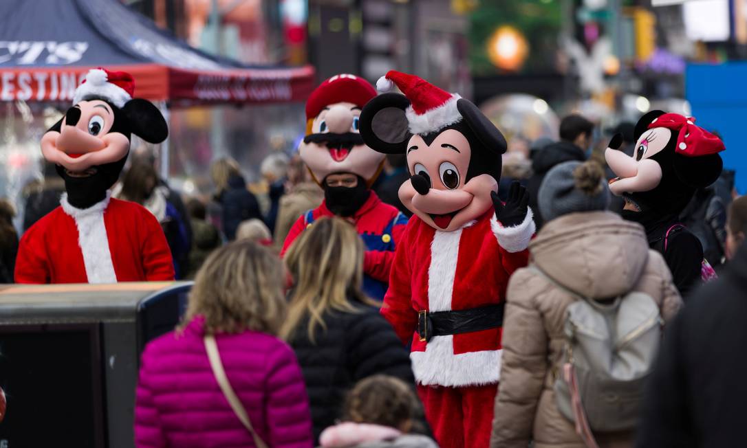 Um homem vestido de Mickey Mouse tira fotos em rua de Nova York Foto: EDUARDO MUNOZ / REUTERS