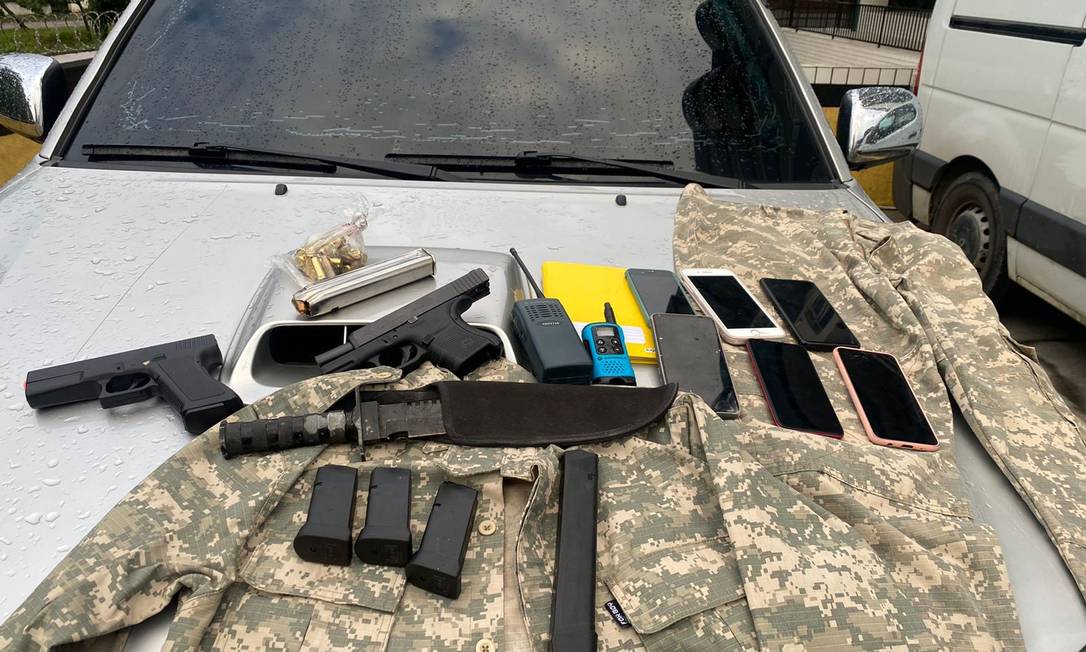 Pistola, fardam celuares e rádios apreendidos pela polícia em Campo Grande Foto: Reprodução