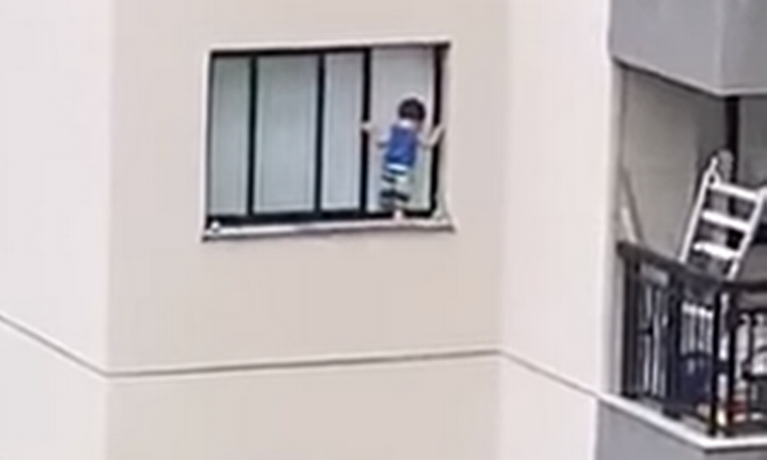 A criança pendurada na janela do edifício Foto: Facebook / Reprodução