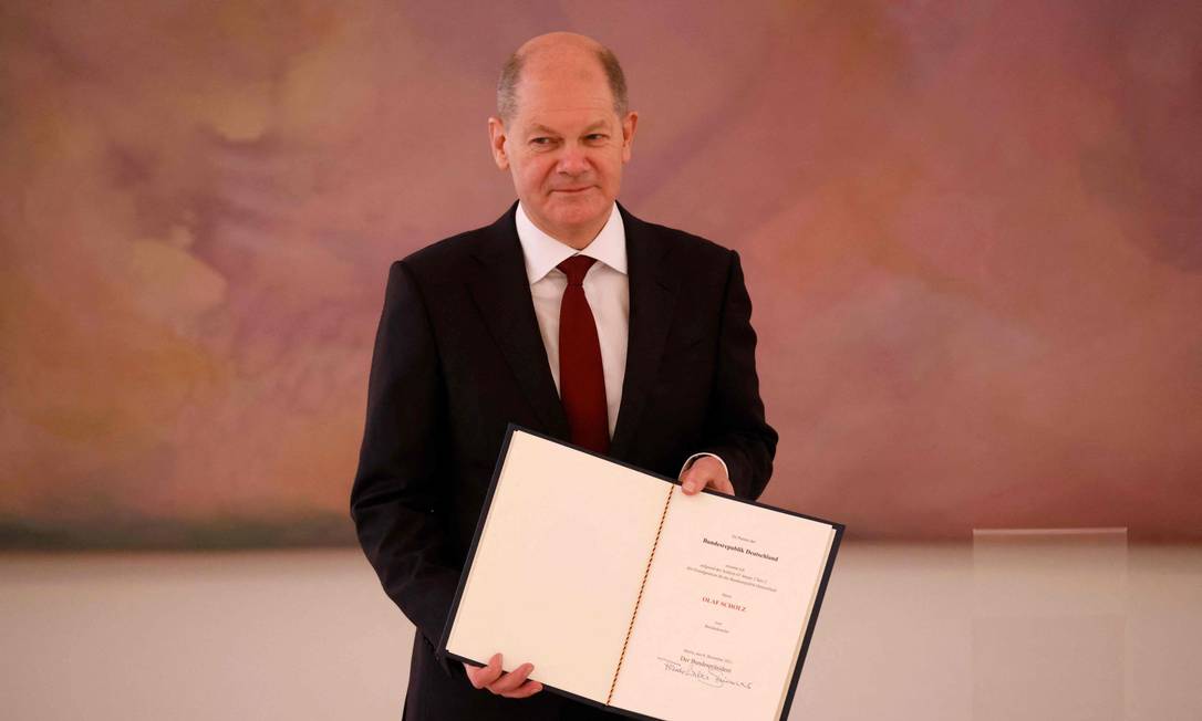 Olaf Scholz posa com seu certificado de nomeação como novo chanceler da Alemanha Foto: ODD ANDERSEN / AFP
