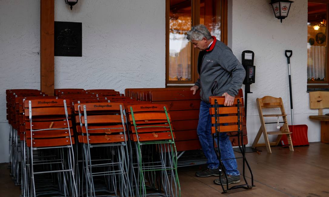 Trabajador retira mesas y sillas de su destilería después de ser encerrado en Estocolmo, Alemania Foto cortesía: Michael Rehley / Reuters